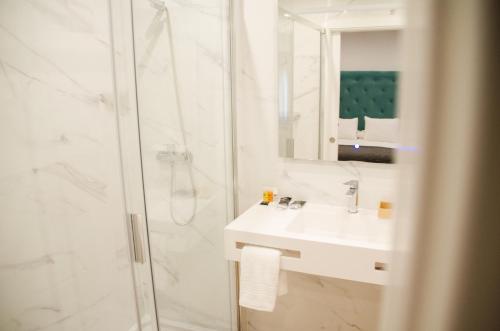 La salle de bains blanche est pourvue d'une douche et d'un lavabo. dans l'établissement Acetres 5, à Séville