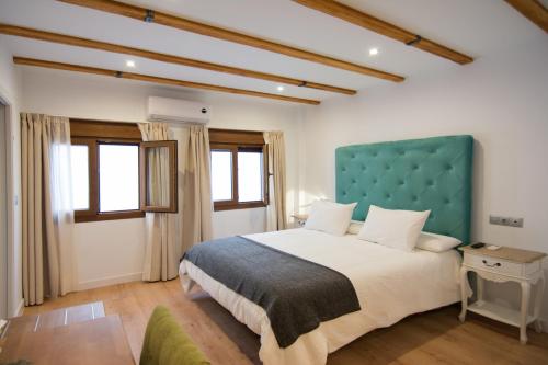 une chambre avec un grand lit et une tête de lit bleue dans l'établissement Acetres 5, à Séville
