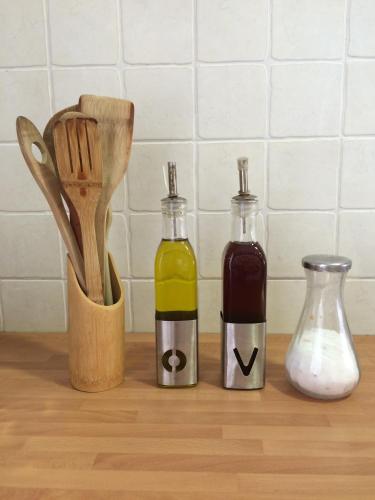 three bottles of sauce and a mortar and pestle on a kitchen counter at Casa la Barbacana in Barbastro