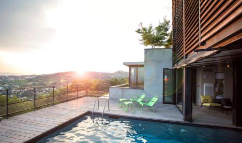 a house with a swimming pool on a balcony at L'Ermitage Hôtel Cuisine-À-Manger in Saint-Cyr-au-Mont-dʼOr