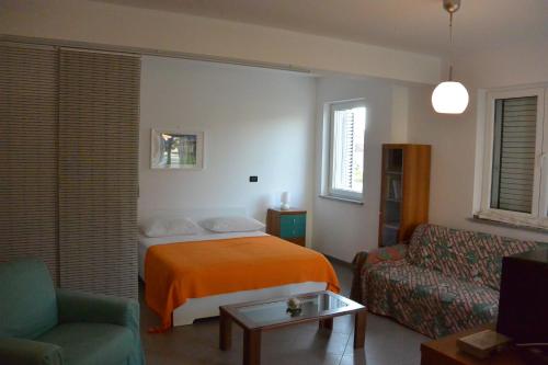 een slaapkamer met een bed, een bank en een stoel bij Apartments Residence L'Ulivo in Rovinj
