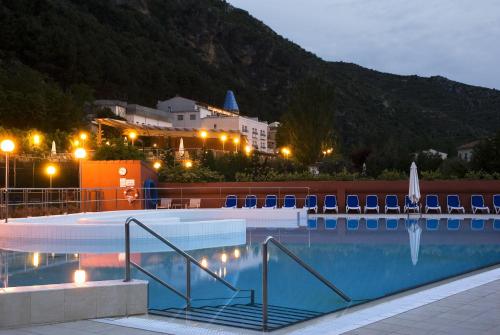 Una piscina de noche con un edificio al fondo. en Hotel SPA TermaEuropa Balneario Arnedillo, en Arnedillo
