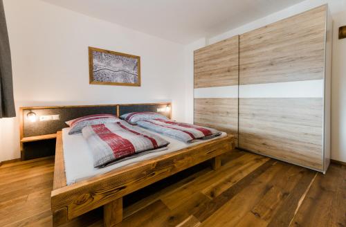 a bedroom with a wooden bed with two pillows at Appartment Sorgenfrei in Altenmarkt im Pongau