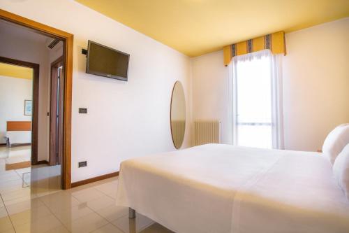 a bedroom with a white bed and a television at BEST WESTERN Titian Inn Hotel Venice Airport in Tessera