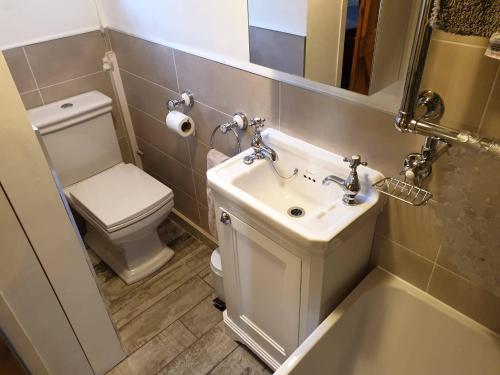 a bathroom with a sink and a toilet at Crosland Cottage in Holmfirth