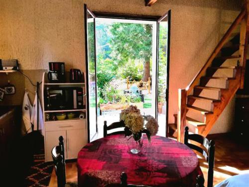 a room with a table with a vase of flowers on it at Studio duplex 2 Lac des Montagnès in Mazamet