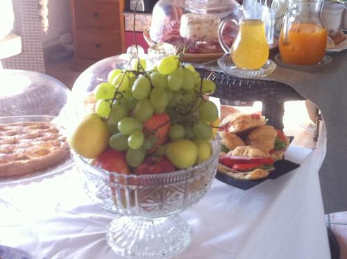 a table with a bowl of grapes and other foods at Casa tipica siciliana patronale home BedandBreakfast TreMetriSoprailCielo Camere con vista, colazione interna in terrazzo panoramico in Caltagirone