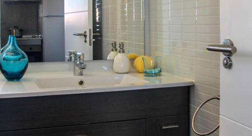 een badkamer met een wastafel en een blauwe vaas bij Apartamento El Hechizo Alto in Albacete