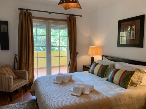 sypialnia z dużym łóżkiem z ręcznikami w obiekcie T2 Portucale Apartment w mieście Casal da Lagoa Seca