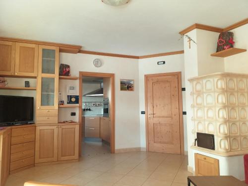 リヴィーニョにあるAppartamento Girasoleの木製のキャビネットとドア付きの広いキッチン