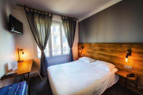 Ένα ή περισσότερα κρεβάτια σε δωμάτιο στο Hôtel Victor Hugo Lorient