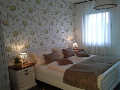 ein Schlafzimmer mit einem großen Bett mit Blumen an der Wand in der Unterkunft Gasthaus Hinterländer Schweiz in Gladenbach