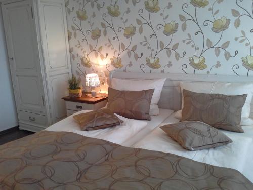 ein Schlafzimmer mit einem Bett und einem Tisch mit einer Lampe in der Unterkunft Gasthaus Hinterländer Schweiz in Gladenbach