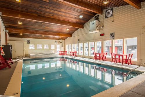 a swimming pool in a building with red chairs at Mountain Modern Motel in Jackson