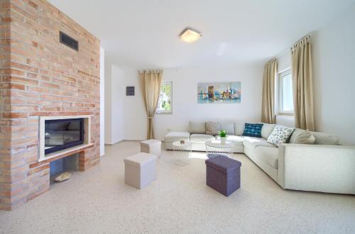 a living room with a couch and a brick fireplace at Villa St. Martin-Reef in Martinšćica