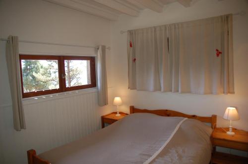 sypialnia z łóżkiem i dwoma stołami z lampkami w obiekcie Chalet Vue sous cet Angles w mieście Les Angles