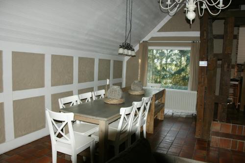 ein Esszimmer mit einem Tisch, Stühlen und einem Fenster in der Unterkunft Eifelhoeve in Benenberg in Hellenthal
