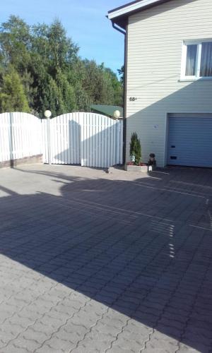 a parking lot in front of a white fence at Mustvee Creek Cottage in Mustvee