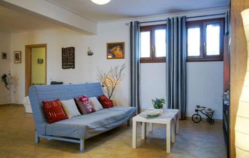 a living room with a blue couch and a table at Anemona Apartment in Mithymna