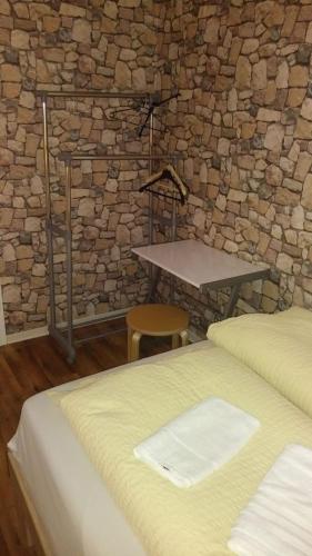 una camera da letto con un muro in pietra, un letto e un tavolo di Sleep Well Rooms a Stoccarda