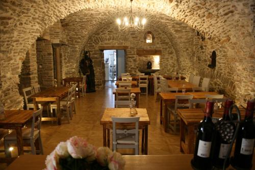 a restaurant with wooden tables and wine bottles at Castel chambres in Malves