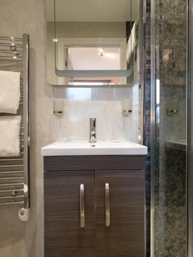 y baño con lavabo y ducha. en Compston House B & B, en Ambleside