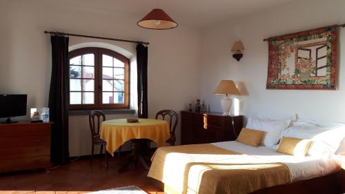 1 dormitorio con cama, mesa y ventana en Estúdio Mateus, en Areia Branca