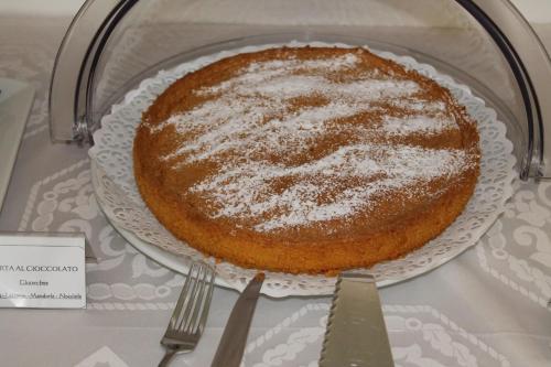 una torta seduta su un piatto su un tavolo di Hotel Escorial a Cervia