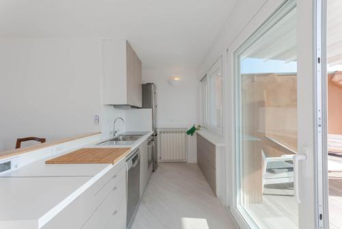 a kitchen with white counters and a sink at Exclusive rooftop apartment with large terrace in Solari/Tortona in Milan