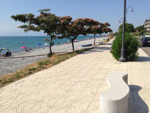 a sidewalk next to a beach with trees and a street light at Hotel Ristorante Stellato in Trebisacce