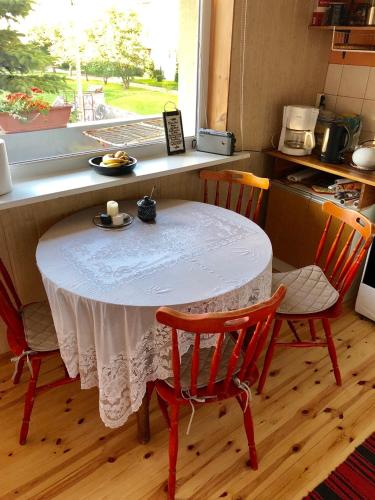 a table in a kitchen with two chairs and a window at Wind Rose apartment in Kuressaare