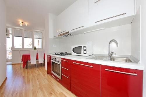 扎達爾的住宿－Bay bridge center apartment 1，一间带红色橱柜和水槽的厨房