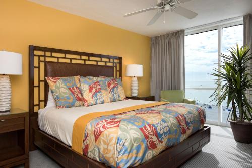 a bedroom with a large bed and a large window at GullWing Beach Resort in Fort Myers Beach