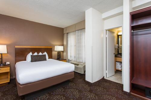 a hotel room with a large bed and a walk in closet at Days Inn by Wyndham Washington DC/Connecticut Avenue in Washington, D.C.