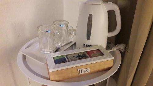 a table with a tea kettle and glasses on it at La Casa di Nina in La Maddalena