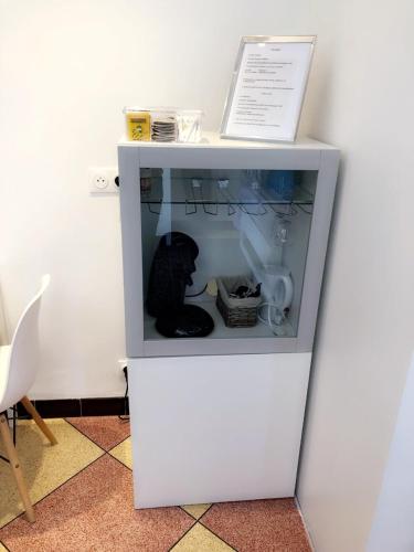 a black cat sitting inside of a white cabinet at Chambre Olivier in Arles