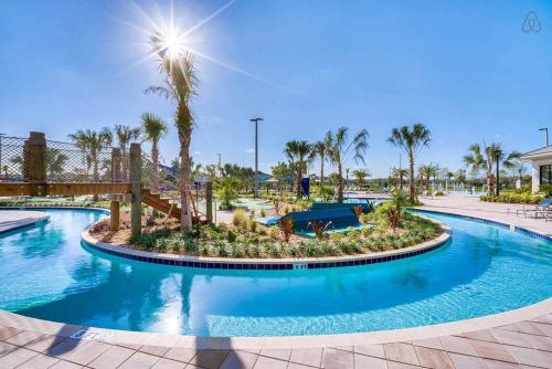 a pool at a resort with palm trees at F - New 4 Bedroom Home - 5 Miles to Disney - Free Water Park - Private Pool in Kissimmee