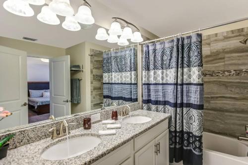 a bathroom with two sinks and a large mirror at F - New 4 Bedroom Home - 5 Miles to Disney - Free Water Park - Private Pool in Kissimmee