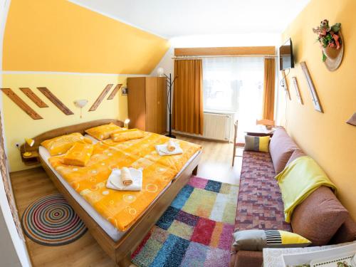 sypialnia z łóżkiem i kanapą w obiekcie Apartments and Rooms Ražen w Bohinju