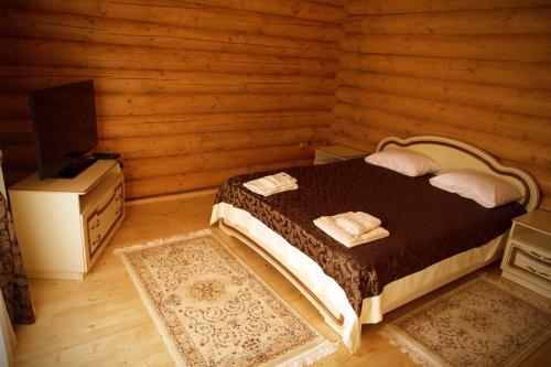 a bedroom with a bed in a wooden room at Oasis Karpat in Polyana