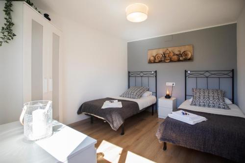 a bedroom with two beds and a table in it at Apartamento El Sauce de Amalia in Celorio