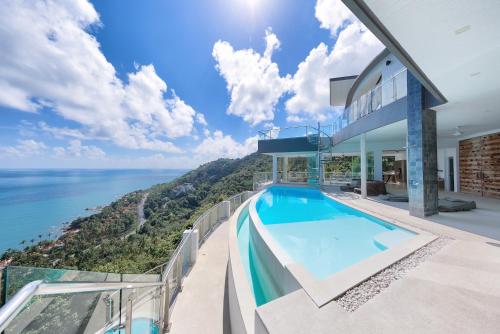 einen Meerblick vom Balkon eines Hauses mit Pool in der Unterkunft Villa Seawadee - luxurious, award-winning design Villa with amazing panoramic seaview in Strand Chaweng Noi