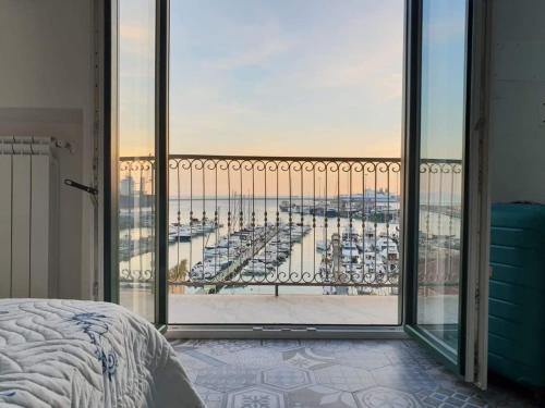 una camera da letto con balcone affacciato sul porto di Nereidi Suites a Salerno