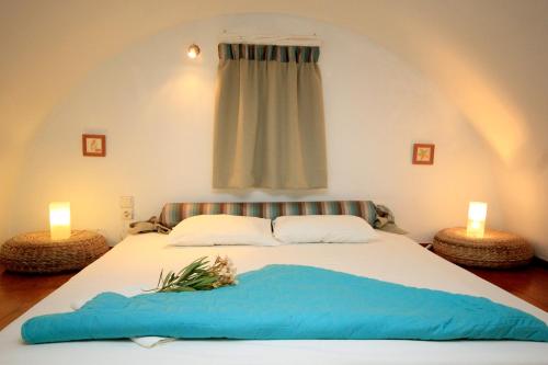 a bedroom with a large bed with two candles at Thea Luxury Resort in Fira