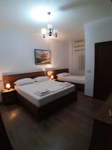 a bedroom with two beds and a chandelier at Villa Juri Garden in Berat