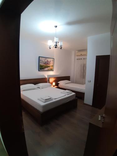 a bedroom with two beds and a chandelier at Villa Juri Garden in Berat