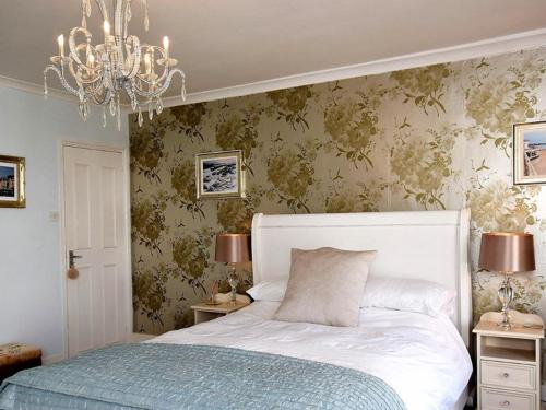 a bedroom with a white bed and a chandelier at Decimus in St. Leonards