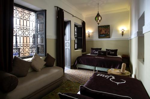 a hotel room with two beds and a couch at Riad Ciel d'Orient in Marrakech