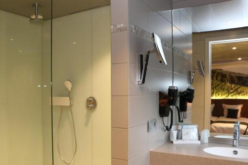 y baño con ducha y lavamanos. en Hotel Botteltje en Ostende