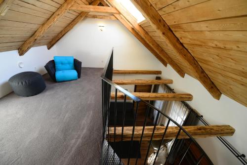 a room with a staircase and a blue chair at Apartments Mitterhof 1544 in Brunico